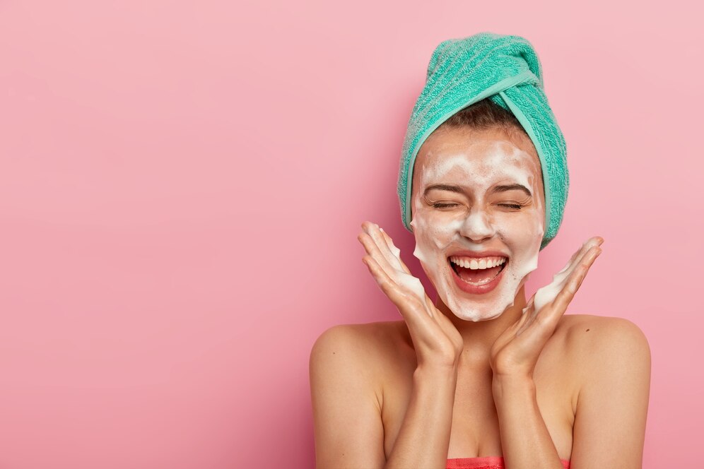 face-care-women-happy-face-covered-in-foam-green-towel